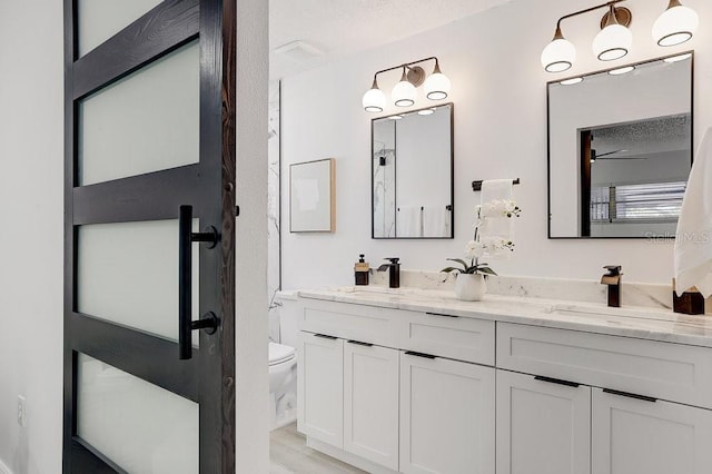 4907 21st Ave W, Bradenton, FL 34209 - full bathroom featuring a sink, toilet, double vanity, and a textured ceiling