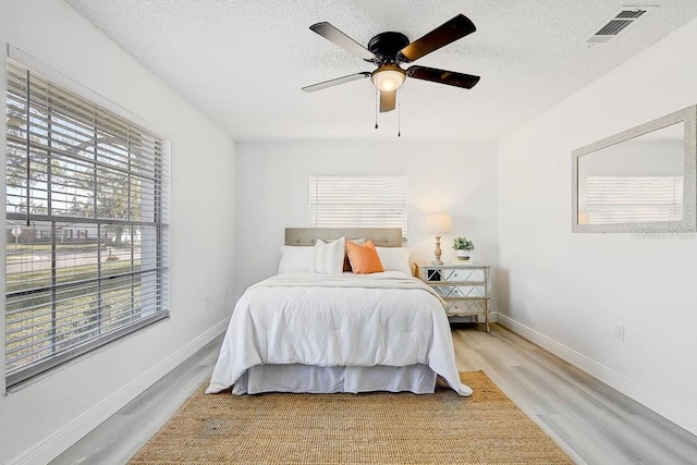 4907 21st Ave W, Bradenton, FL 34209 - bedroom featuring visible vents, baseboards, light wood-style floors, and a textured ceiling