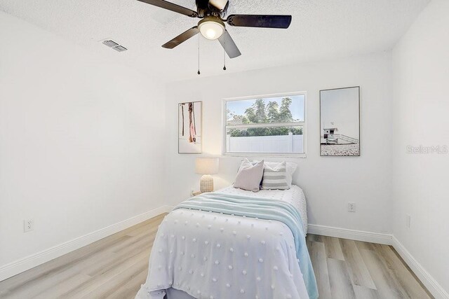 4907 21st Ave W, Bradenton, FL 34209 - bedroom with visible vents, baseboards, light wood-style floors, and a textured ceiling