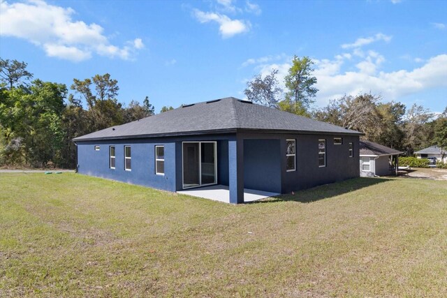 1973 E Celina St, Inverness, FL 34453 - rear view of property with a patio, a lawn, stucco siding, and a shingled roof