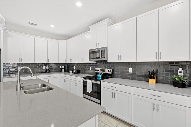 1551 Flange Dr, Davenport, FL 33896 - kitchen with tasteful backsplash, visible vents, stainless steel appliances, and a sink