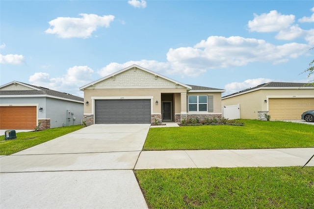 view of front facade featuring a front yard, stucco siding, driveway, stone siding, and an attached garage