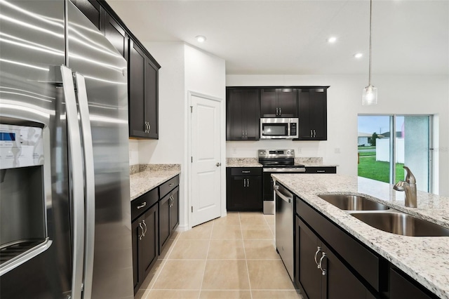 kitchen with light tile patterned flooring, recessed lighting, a sink, stainless steel appliances, and decorative light fixtures