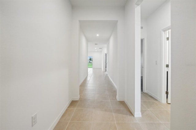 hallway featuring light tile patterned flooring and baseboards