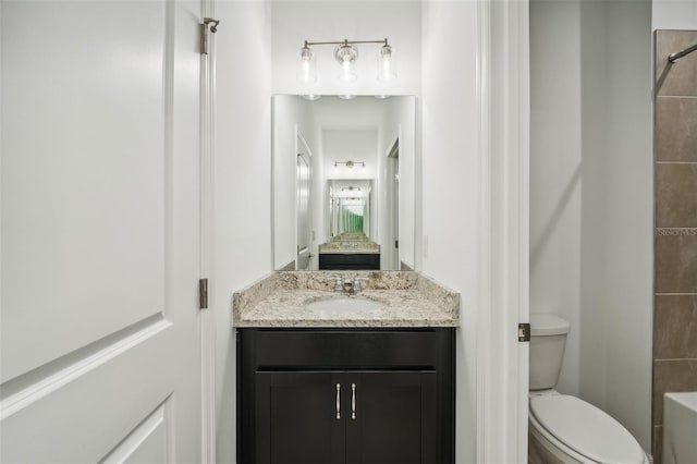 bathroom with vanity, toilet, and connected bathroom