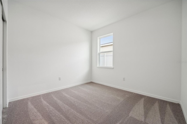 carpeted empty room with baseboards