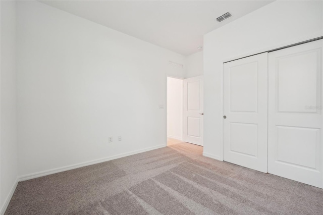 unfurnished bedroom featuring a closet, baseboards, visible vents, and carpet floors