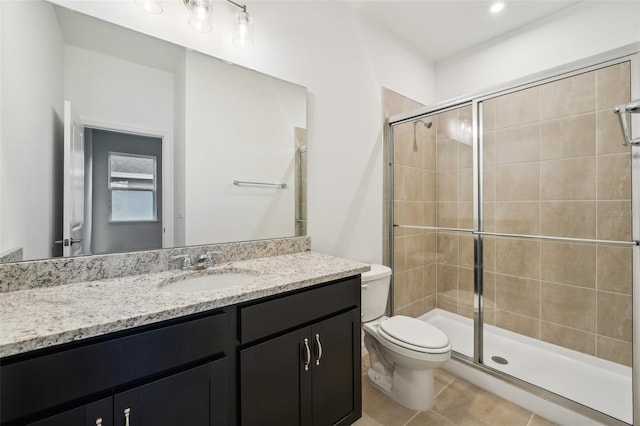 full bath featuring tile patterned flooring, a stall shower, toilet, and vanity