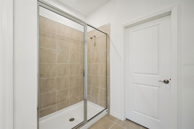 bathroom with a shower stall and tile patterned flooring