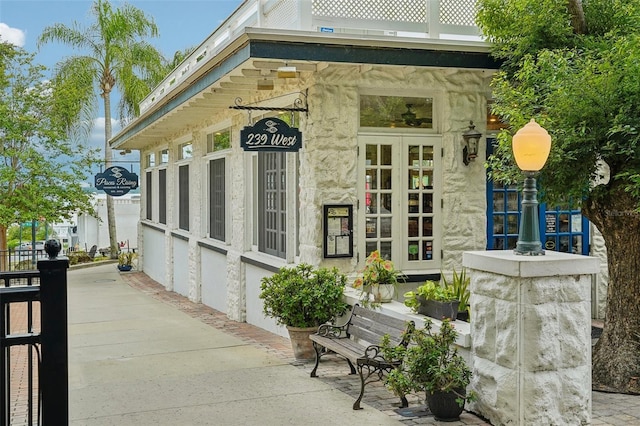 exterior space featuring french doors and stone siding