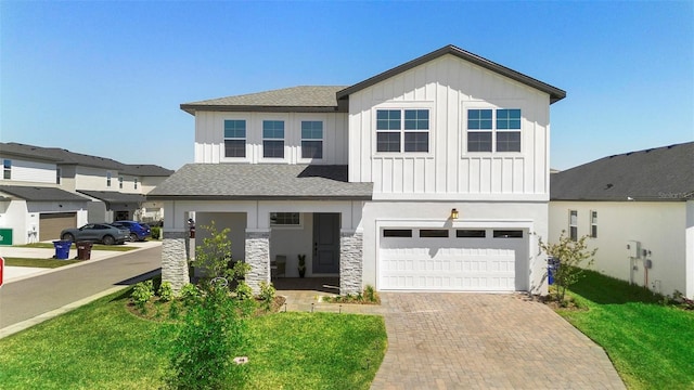 4911 Shady Pines Dr, Saint Cloud, FL 34772 - view of front of property featuring board and batten siding, an attached garage, decorative driveway, roof with shingles, and a front yard