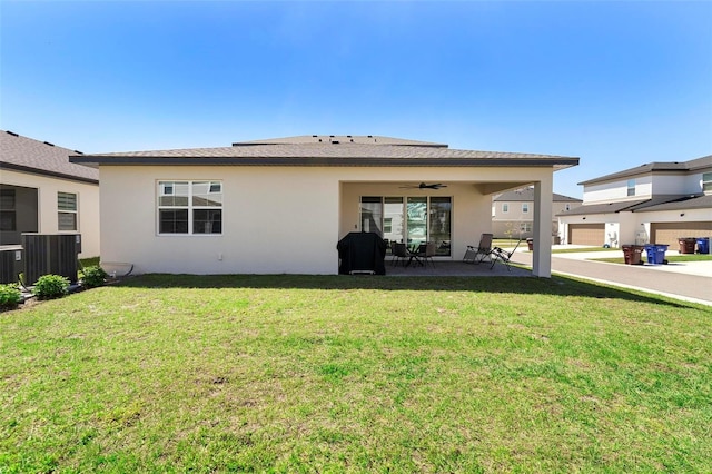 4911 Shady Pines Dr, Saint Cloud, FL 34772 - rear view of house with stucco siding, a ceiling fan, a patio, central AC unit, and a yard