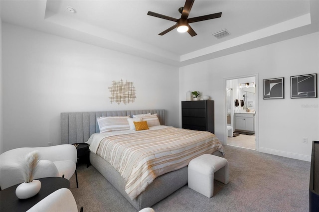 4911 Shady Pines Dr, Saint Cloud, FL 34772 - bedroom featuring light colored carpet, a tray ceiling, baseboards, connected bathroom, and a ceiling fan