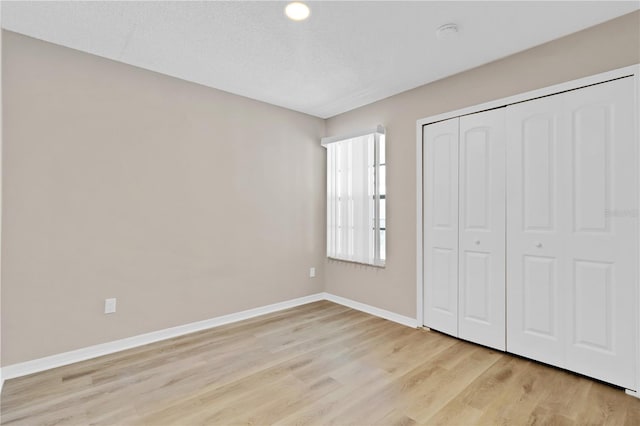 2007 Royal Bay Blvd Unit 144, Kissimmee, FL 34746 - unfurnished bedroom featuring baseboards, a closet, and light wood-style flooring
