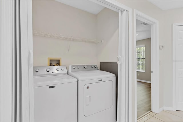 2007 Royal Bay Blvd Unit 144, Kissimmee, FL 34746 - laundry room featuring washer and clothes dryer, baseboards, light tile patterned flooring, visible vents, and laundry area