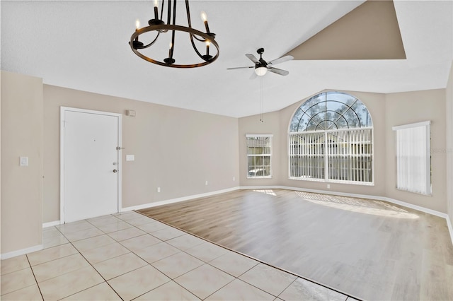 2007 Royal Bay Blvd Unit 144, Kissimmee, FL 34746 - unfurnished room featuring light tile patterned floors, ceiling fan with notable chandelier, lofted ceiling, and baseboards