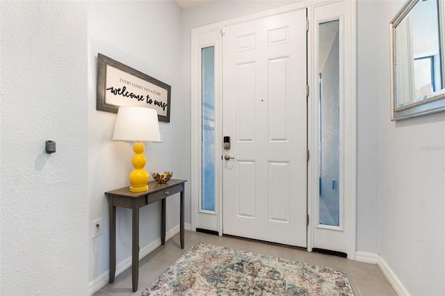 foyer with light tile patterned floors and baseboards