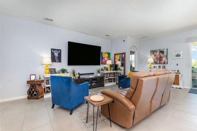 living area with light tile patterned floors, a wealth of natural light, and visible vents