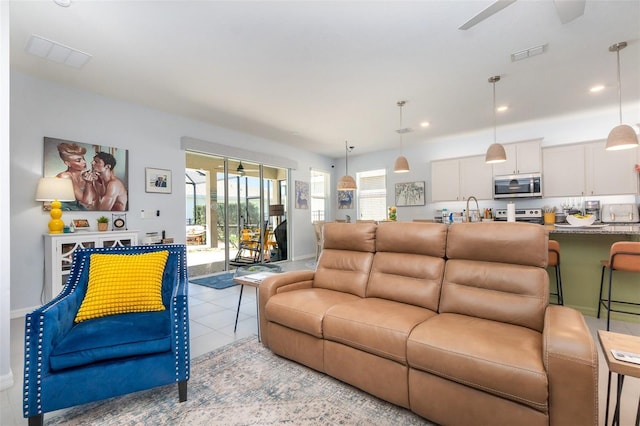 living area featuring light tile patterned floors, visible vents, recessed lighting, and a ceiling fan