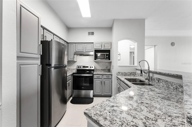3384 Corona Village Way Unit 202, Orlando, FL 32835 - kitchen featuring gray cabinets, a sink, under cabinet range hood, light tile patterned floors, and stainless steel appliances