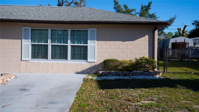 345 W Seminole Ave, Eustis, FL 32726 - view of side of home featuring concrete block siding, a shingled roof, and a patio