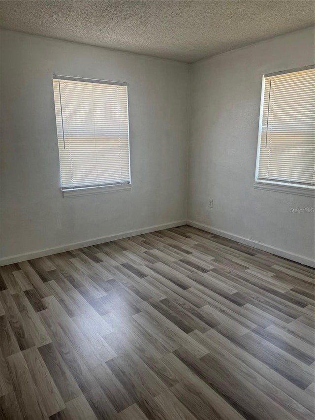 345 W Seminole Ave, Eustis, FL 32726 - unfurnished room featuring wood finished floors, a textured ceiling, and baseboards