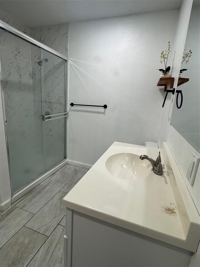 345 W Seminole Ave, Eustis, FL 32726 - bathroom with vanity, a marble finish shower, and baseboards
