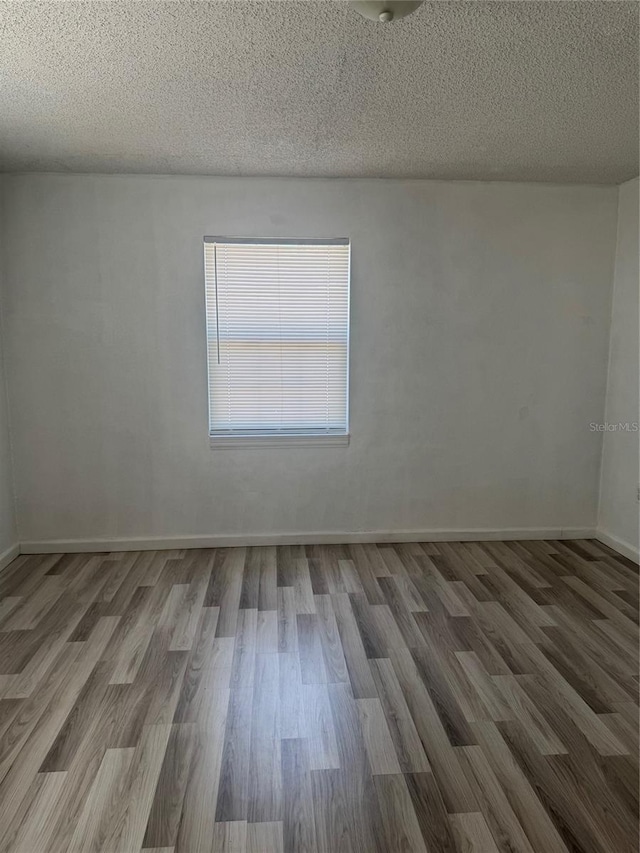 345 W Seminole Ave, Eustis, FL 32726 - unfurnished room with wood finished floors, a textured ceiling, and baseboards