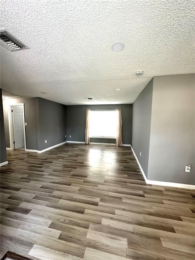345 W Seminole Ave, Eustis, FL 32726 - empty room featuring a textured ceiling, baseboards, and wood finished floors