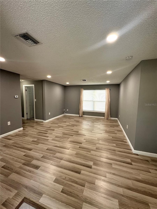 345 W Seminole Ave, Eustis, FL 32726 - spare room with light wood-style flooring, a textured ceiling, baseboards, recessed lighting, and a smoke detector