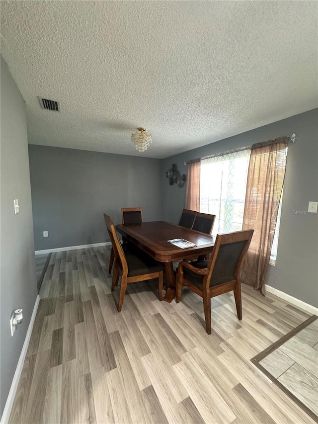 345 W Seminole Ave, Eustis, FL 32726 - dining room featuring a textured ceiling, light wood-type flooring, and baseboards