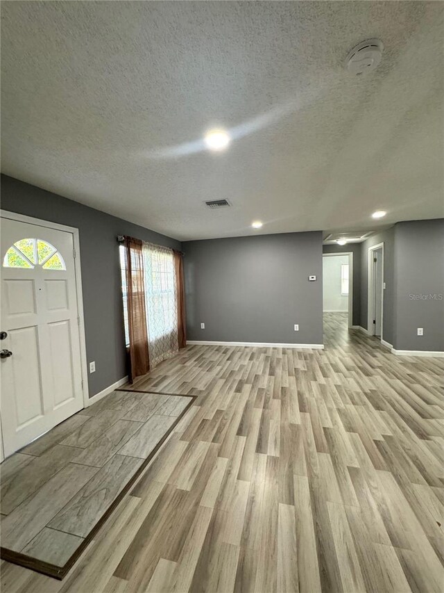 345 W Seminole Ave, Eustis, FL 32726 - entryway featuring light wood-style flooring, baseboards, and a textured ceiling