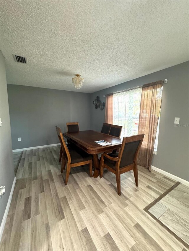 345 W Seminole Ave, Eustis, FL 32726 - dining area with a textured ceiling, light wood finished floors, and baseboards