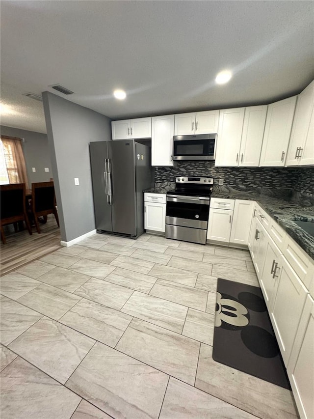 345 W Seminole Ave, Eustis, FL 32726 - kitchen with appliances with stainless steel finishes, tasteful backsplash, white cabinetry, and baseboards