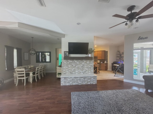 living area with baseboards, a ceiling fan, and wood finished floors