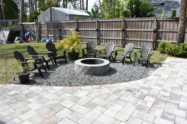 view of patio featuring fence, an outdoor fire pit, and a playground