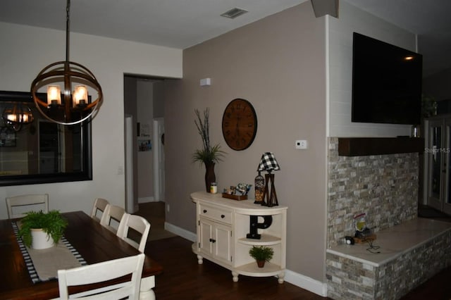 dining room featuring a notable chandelier, visible vents, baseboards, and dark wood-style floors