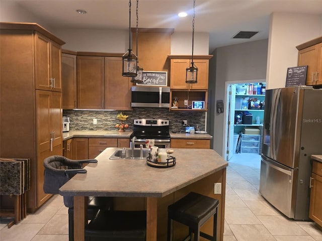 kitchen featuring decorative backsplash, appliances with stainless steel finishes, and light tile patterned flooring