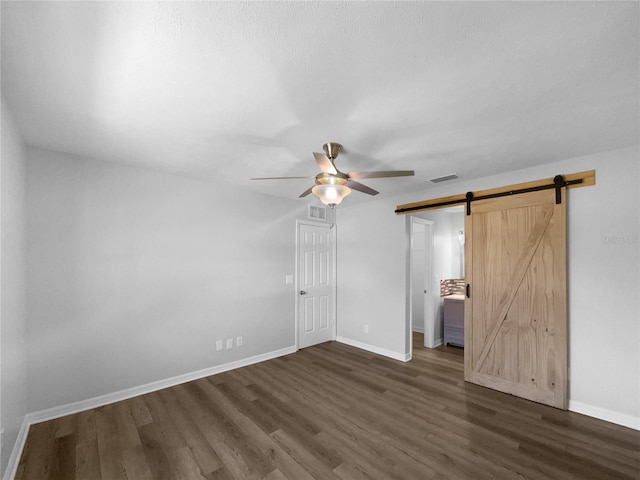 6 Almond Trce, Ocala, FL 34472 - unfurnished bedroom with a barn door, dark wood-style floors, visible vents, and baseboards