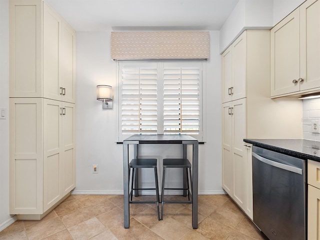 kitchen featuring dishwasher, baseboards, decorative backsplash, and dark countertops