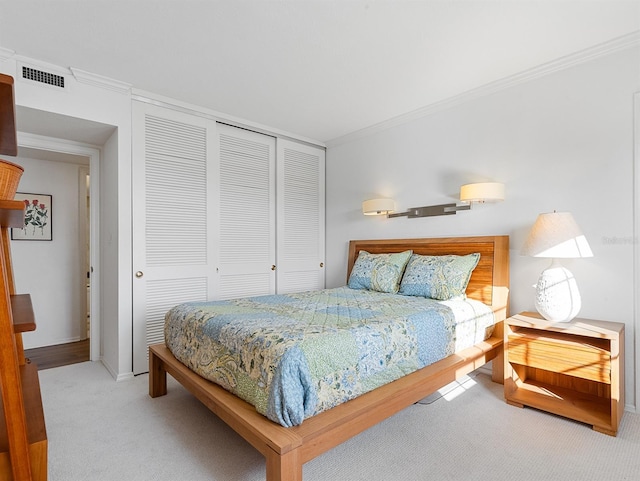 carpeted bedroom featuring visible vents, a closet, and crown molding