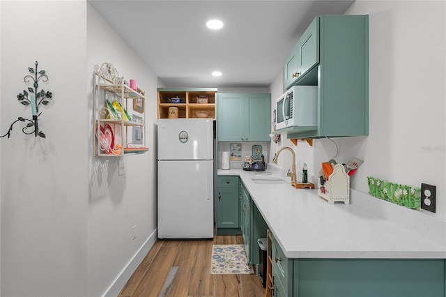 407 E Jersey St, Orlando, FL 32806 - kitchen with green cabinets, light countertops, wood finished floors, white appliances, and a sink