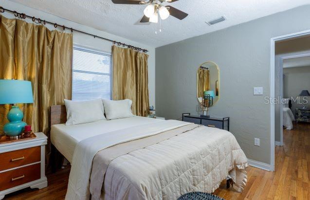 407 E Jersey St, Orlando, FL 32806 - bedroom with visible vents, ceiling fan, baseboards, wood finished floors, and a textured ceiling