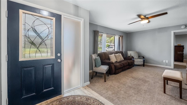 carpeted entryway with baseboards and ceiling fan