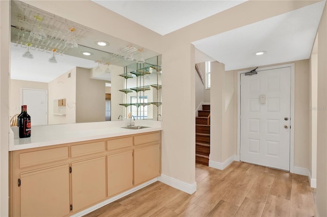 bar with baseboards, stairway, light wood-type flooring, recessed lighting, and a sink