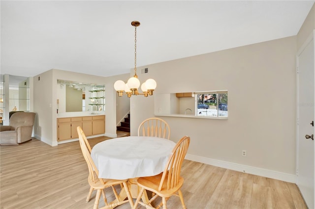dining room featuring visible vents, light wood-style flooring, baseboards, and an inviting chandelier