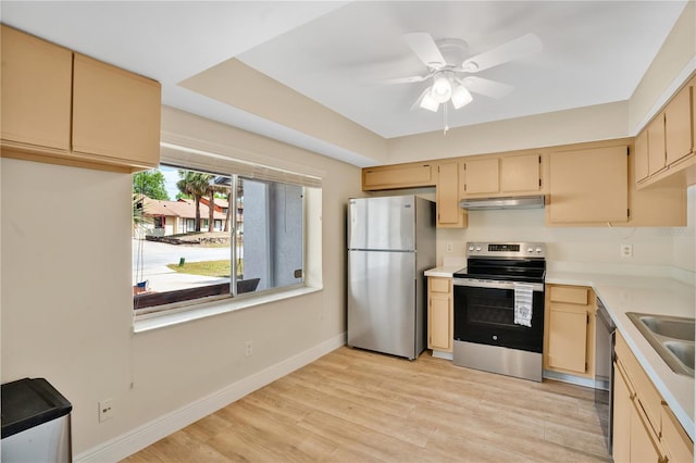 kitchen with under cabinet range hood, appliances with stainless steel finishes, light wood-style flooring, and light countertops