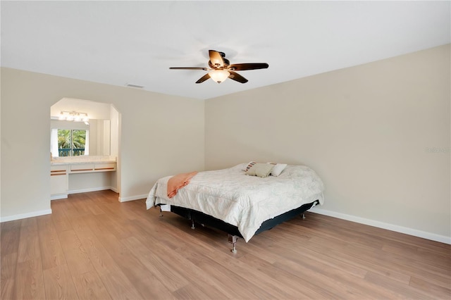 bedroom featuring a ceiling fan, light wood-style flooring, visible vents, and baseboards