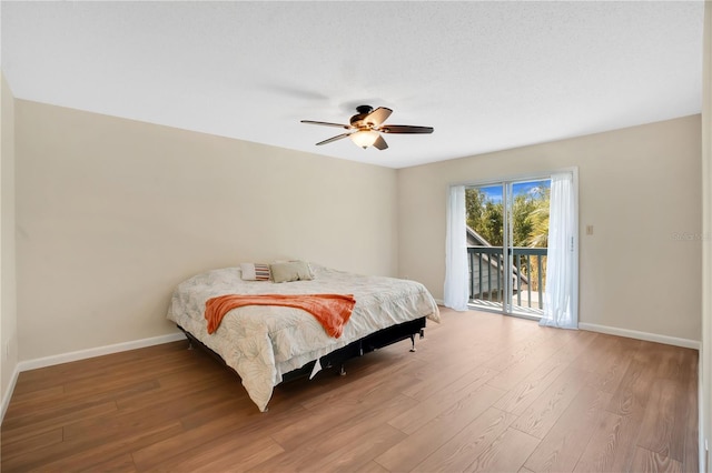 bedroom with baseboards, wood finished floors, access to exterior, and a ceiling fan