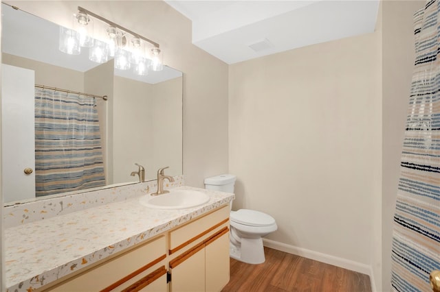 bathroom with visible vents, baseboards, toilet, wood finished floors, and vanity